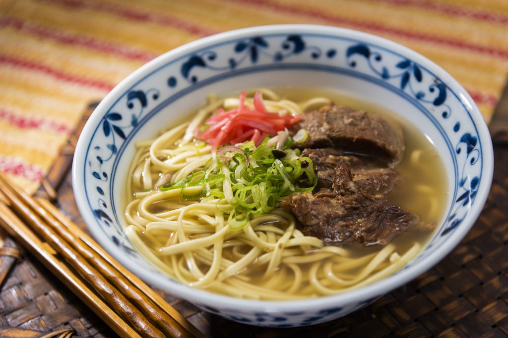 沖縄そばは、太めの麺と、豚骨やカツオ節のだしが特徴の郷土料理