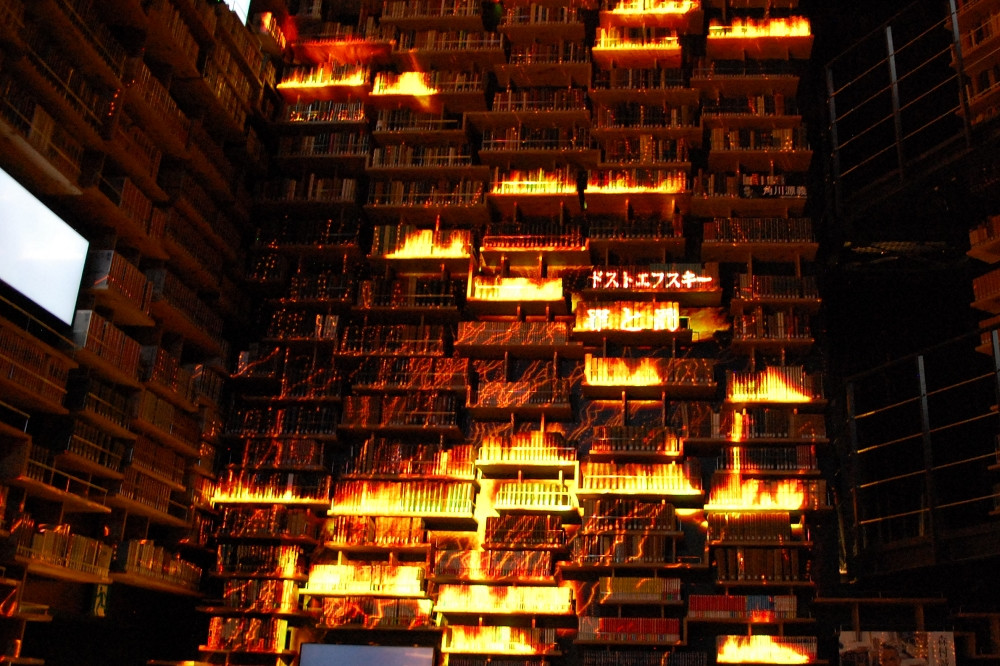  プロジェクションマッピングのひとコマ。本当に書籍が燃えているかのような光景 